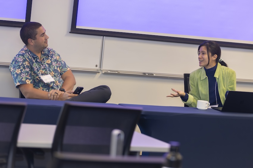 Man sits across from woman as they discuss something during a conference