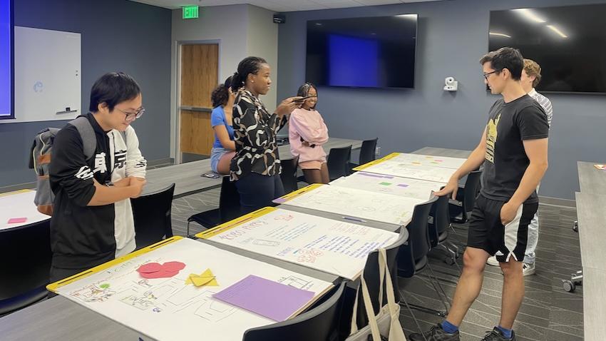 Teacher and students review AI posters made by middle schoolers