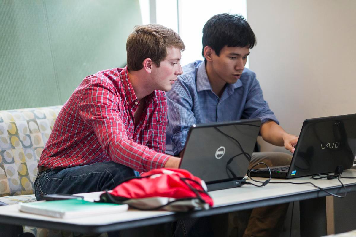 Two students looking at a laptop